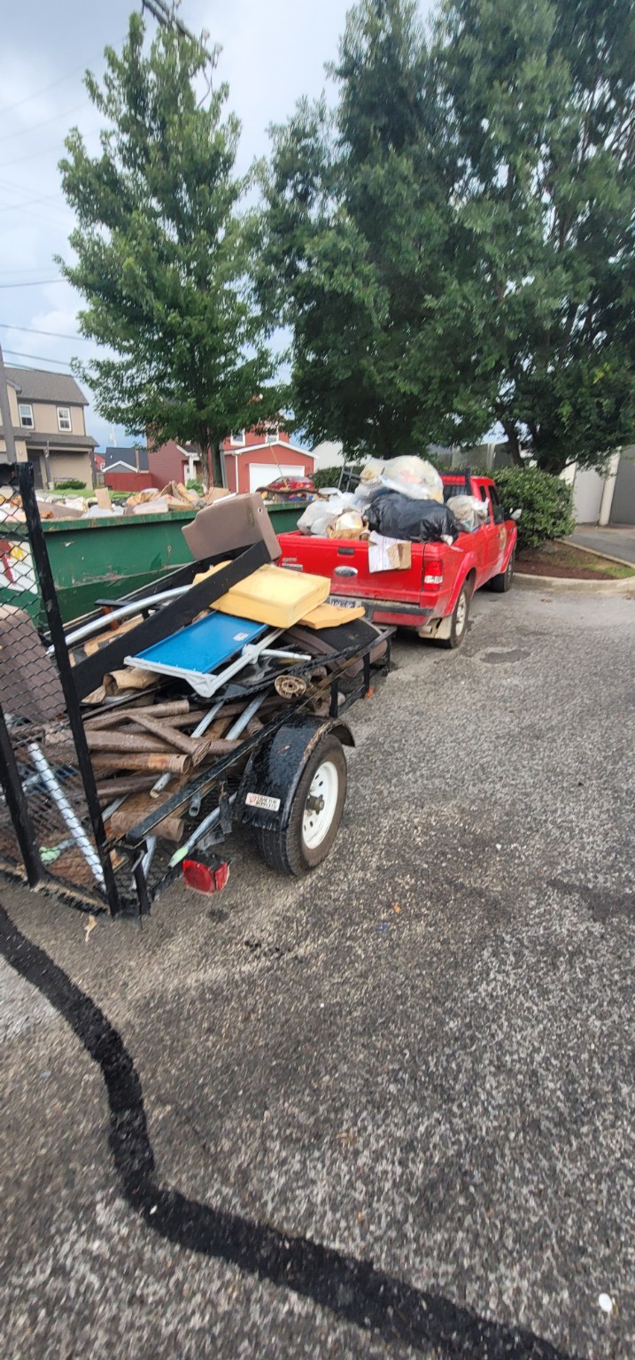 Lewis and Sons red pickup and trailer loaded for junk removal